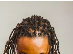 The top of a head of black dreadlocks done in a bricklayer pattern.